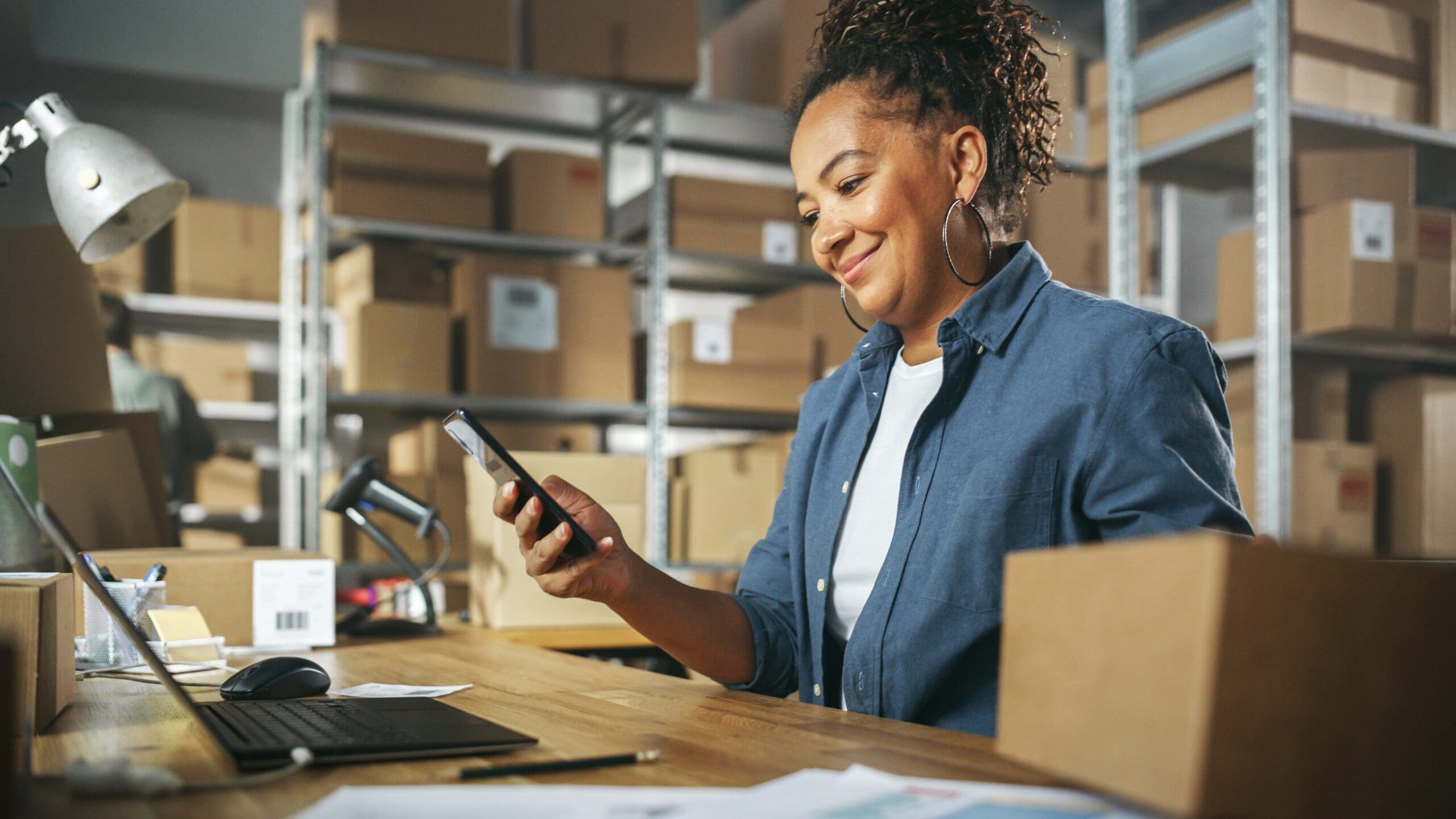 Inventory Manager Using Smartphone To Scan A Barcode On Parcel